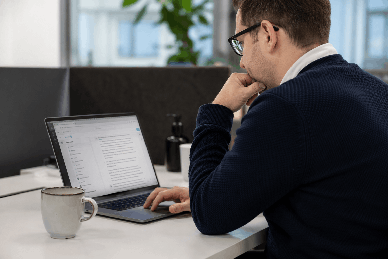 Man sitter vid en laptop och arbetar på kontoret